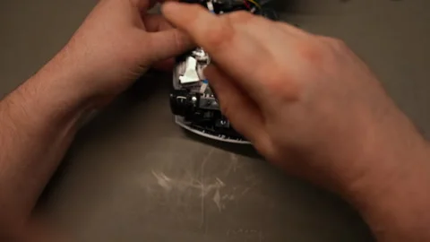 Professional technician repairing gaming controller, using screwdriver with Stock Footage 306892597