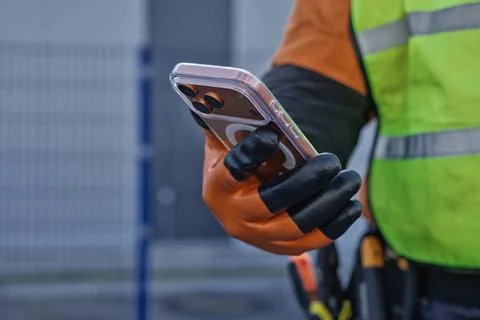 Professional technician uses a mobile device for digital project management.. Stock Photos