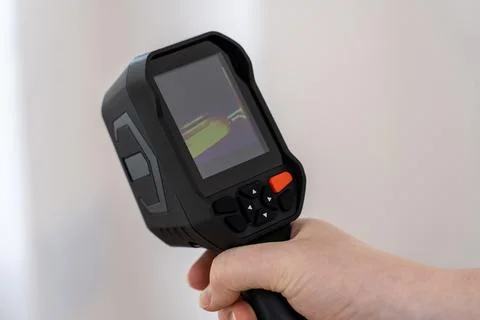 Professional thermal imager with a color-coded screen displays heat distribution Stock Photos