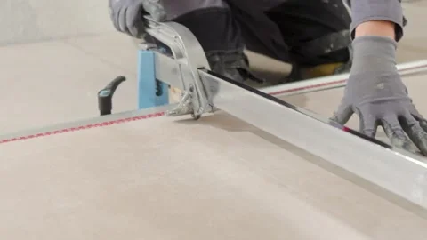 Professional tiler cutting a tile with a big cutting tool. Renovating your Stock Footage 340914093