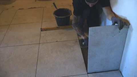 Professional tiler laying ceramic tiles on a floor Stock Footage 346688357