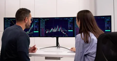 Professional Trader Online Uses Multiple Monitors In Office Workplace Stock Photos