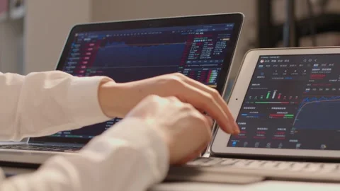 Professional Trader Typing on Laptop Analyzing Financial Charts in Modern Office Vídeos de archivo 336550618