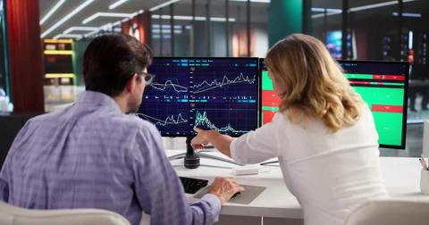 Professional Trader Using Multiple Computer Screens To Analyze Stock Market. Stock Photos