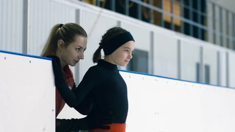 Professional trainer giving advice to her figure-skating pupil Stock Footage 101627734