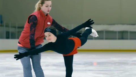 Professional trainer helping figure skating girl to do arabesque Stock Footage 101628718