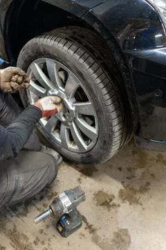 Professional Using an Impact Wrench for Summer Wheel Installation Stock Photos