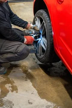 Professional Using Impact Wrench for Winter Wheel Installation Stock Photos