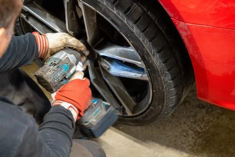 Professional Using Impact Wrench for Winter Wheel Installation Stock Photos