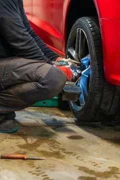 Professional Using Impact Wrench for Winter Wheel Installation Stock Photos