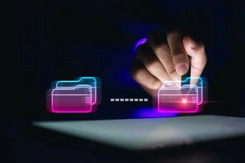 Professional using stylus on tablet with glowing neon digital folders trans.. Stock Photos