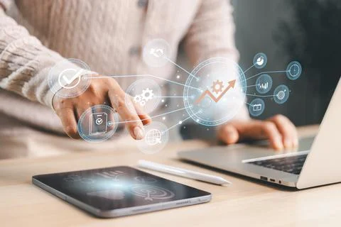 Professional using tablet and laptop with connected growth icons, showing p.. Stock Photos
