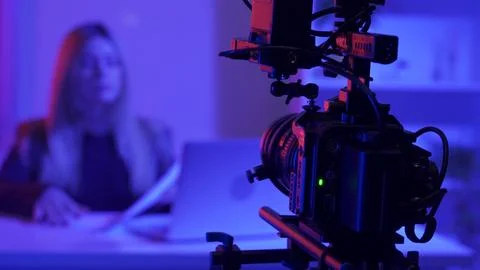 Professional video camera on a tripod against a blurred background of a female Stock Photos