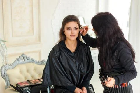 Professional visagist working with model Stock Photos