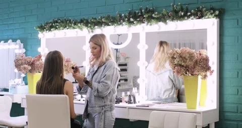Professional visagiste is doing makeup for young model in beauty salon. Vídeo Stock 145465670