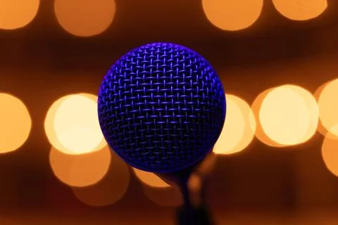 Professional Vocal Microphone with Blue Lighting on Warm Golden Bokeh Backg.. Stock Photos