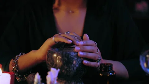 Professional voodoo shaman reading spell over magic potion, touching mortar Stock Footage 201331204