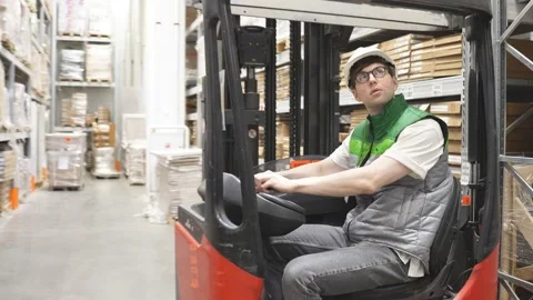 Professional warehouse worker sit inside of machine, doing logistics Stock Footage 140224769