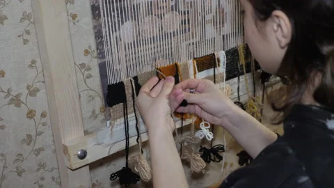 Professional weaver creates handmade carpet on wooden loom Stock Footage 174128697