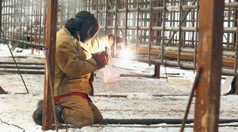 Professional welder welding a metal framework pile, using a mask Stock Footage 36298423