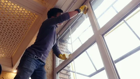 A professional window cleaner soaps and squeegies a window clean, male worker Vidéo 169182075