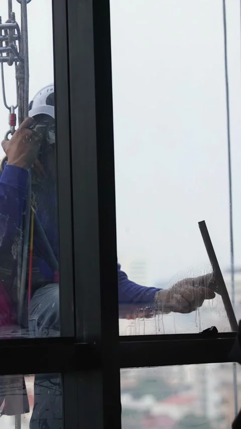 Professional Window Cleaner Using Squeegee on High Rise Skyscraper Stock-Footage 331413835