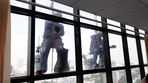Professional Window Cleaners Rappelling Down a High Rise Skyscraper in Bangkok Vídeos de archivo 329658083