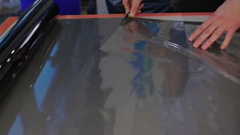 The Professional Windshield Tinting Process Conducted in a Modern Auto Showroom Stock Footage 309965082