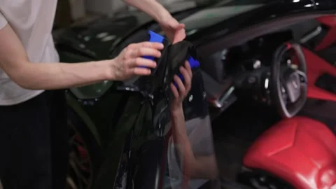 The Professional Windshield Tinting Process Conducted in a Modern Auto Showroom Stock Footage 309965165