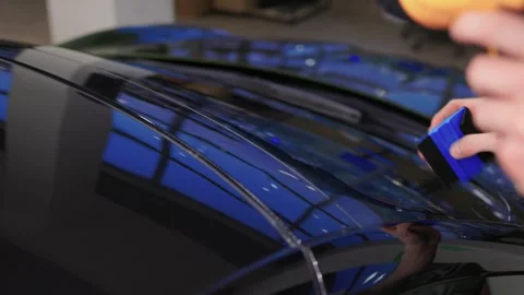 The Professional Windshield Tinting Process Conducted in a Modern Auto Showroom Stock Footage 309965223