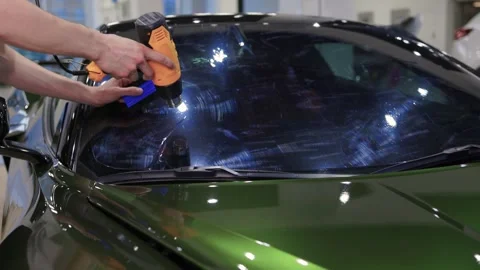 The Professional Windshield Tinting Process Conducted in a Modern Auto Showroom Stock Footage 310012900