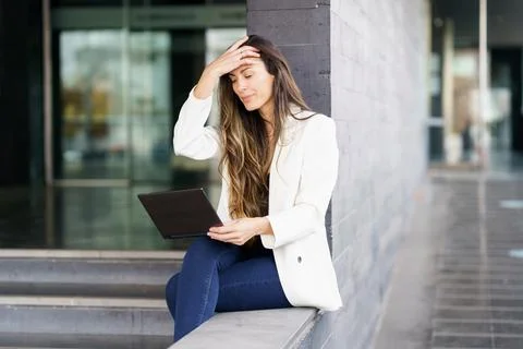 A Professional Woman Engaged in Work Using a Laptop in a Contemporary Office Foto stock