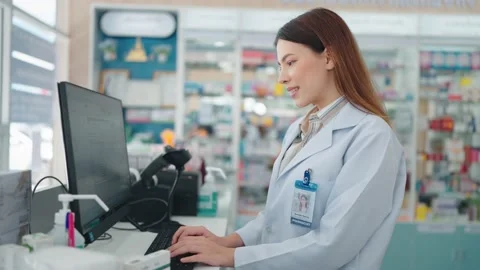 A professional woman pharmacist using a computer to research medicines Видео 211095291
