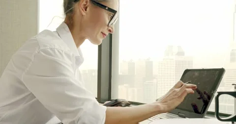 Professional Woman Using Tablet in Office with City View Stock Footage 323575040