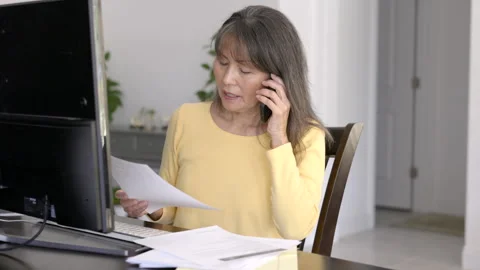 Professional woman working from home on computer talking on smartphone at office Stock Footage 330809378