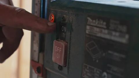 Professional woodworker pushing button on a thickness planer machine in Stock Footage 206035296
