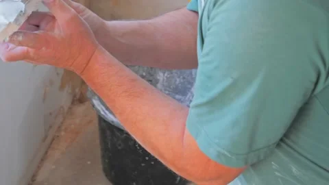 Professional worker applying coating material to the plasterboard wall Stock Footage 142951925