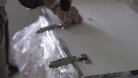 The professional worker attaches the door hinges to the facade. Stock Footage 157288604