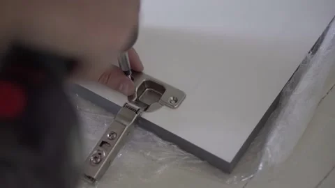 The professional worker attaches the door hinges to the facade. Close up. Stock Footage 157288624