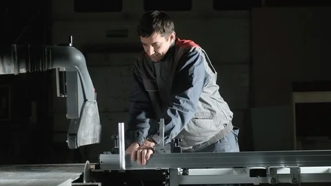 Professional worker cuts a piece of Board with  metal circular saw Blade. Stock Footage 124158060
