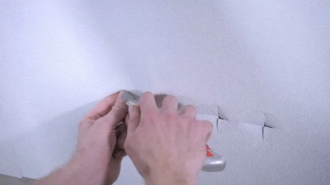 Professional worker cuts off white wallpaper on outlet hole Video stock 108582587