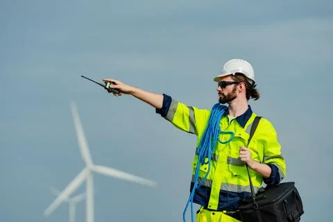 Professional worker directing operations at a wind farm on a clear day in a.. Foto stock