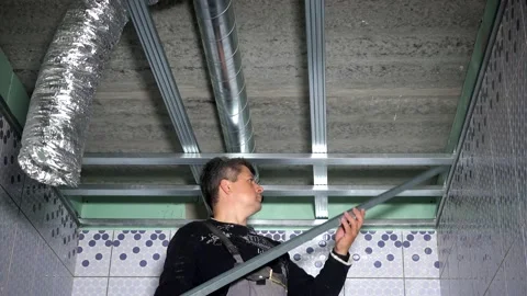 Professional worker fasten ceiling profiles in new flat bathroom Stock Footage 137783163