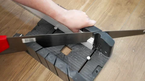 Professional worker fixing white plastic plinth and cutting with sharp hand saw Stock Footage 208421305