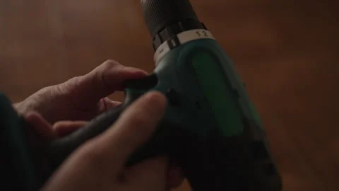 Professional worker inserting battery into cordless electric drill and selecting Stock Footage 342771763