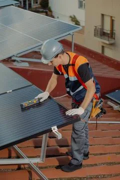 Professional worker installing solar panels on the roof of a house Foto stock