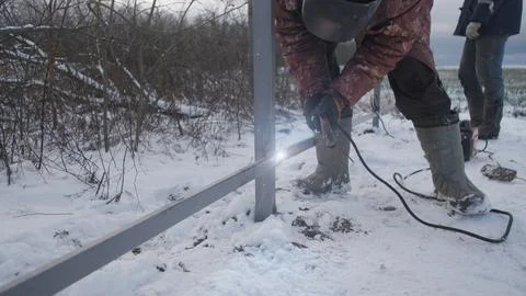 Professional worker performs welding work Stock Photos