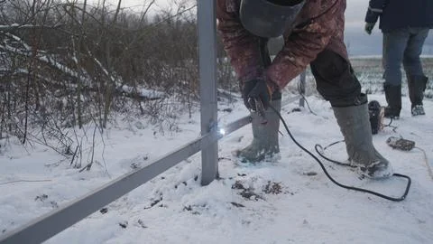 Professional worker performs welding work Stock Photos