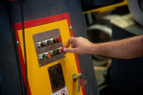 Professional worker pressing buttons on machine control board Stock Photos