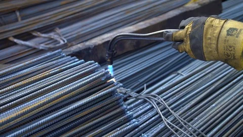 Professional worker processes metal rods with a flame of a welding machine in Stock Footage 113563211